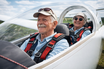 Oudere couple in glider boven het landschap